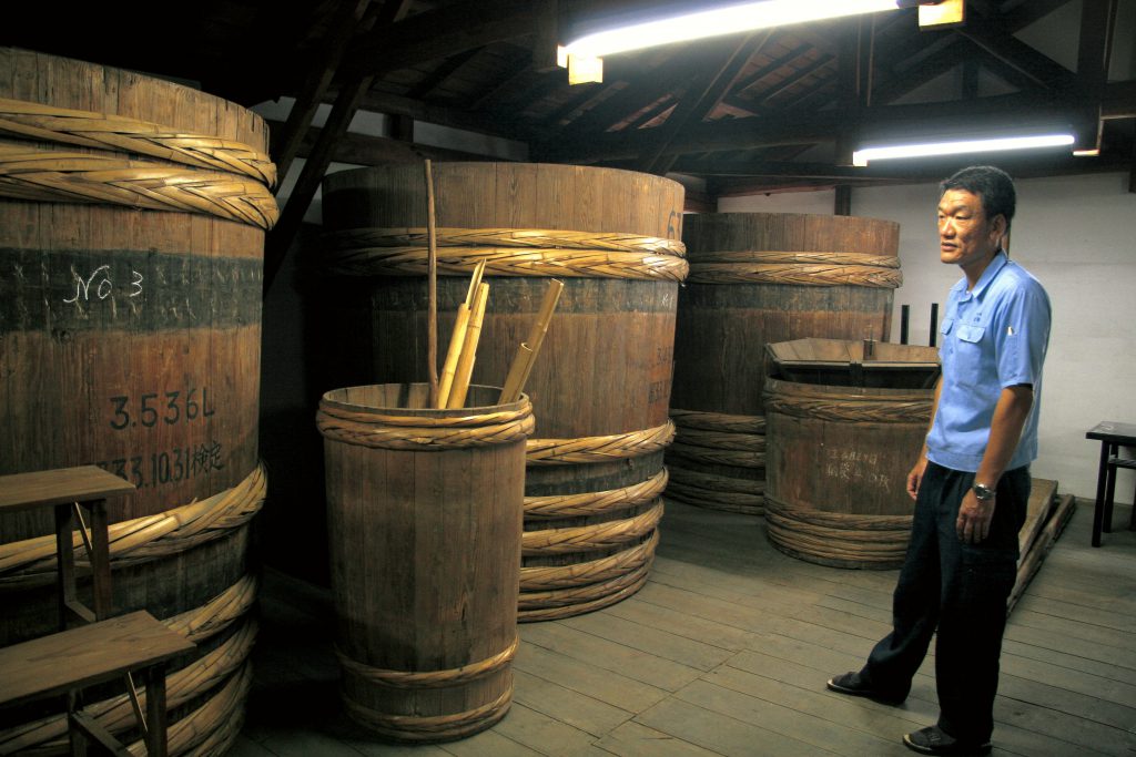 竹鶴酒造の木桶を男性が眺めている。