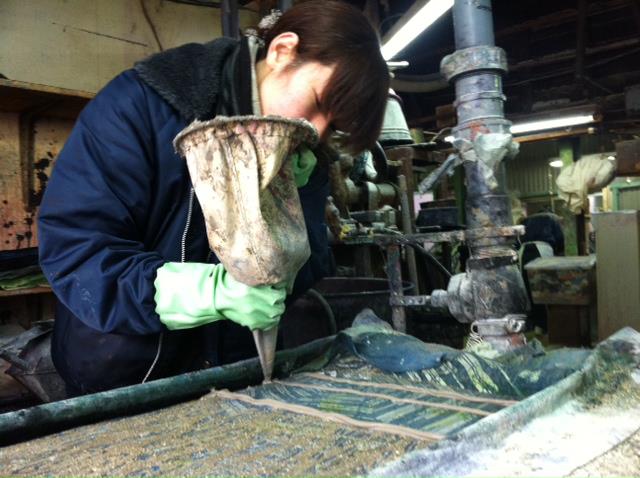 「注染手ぬぐい」の染色工程で土手づくりをしている女性