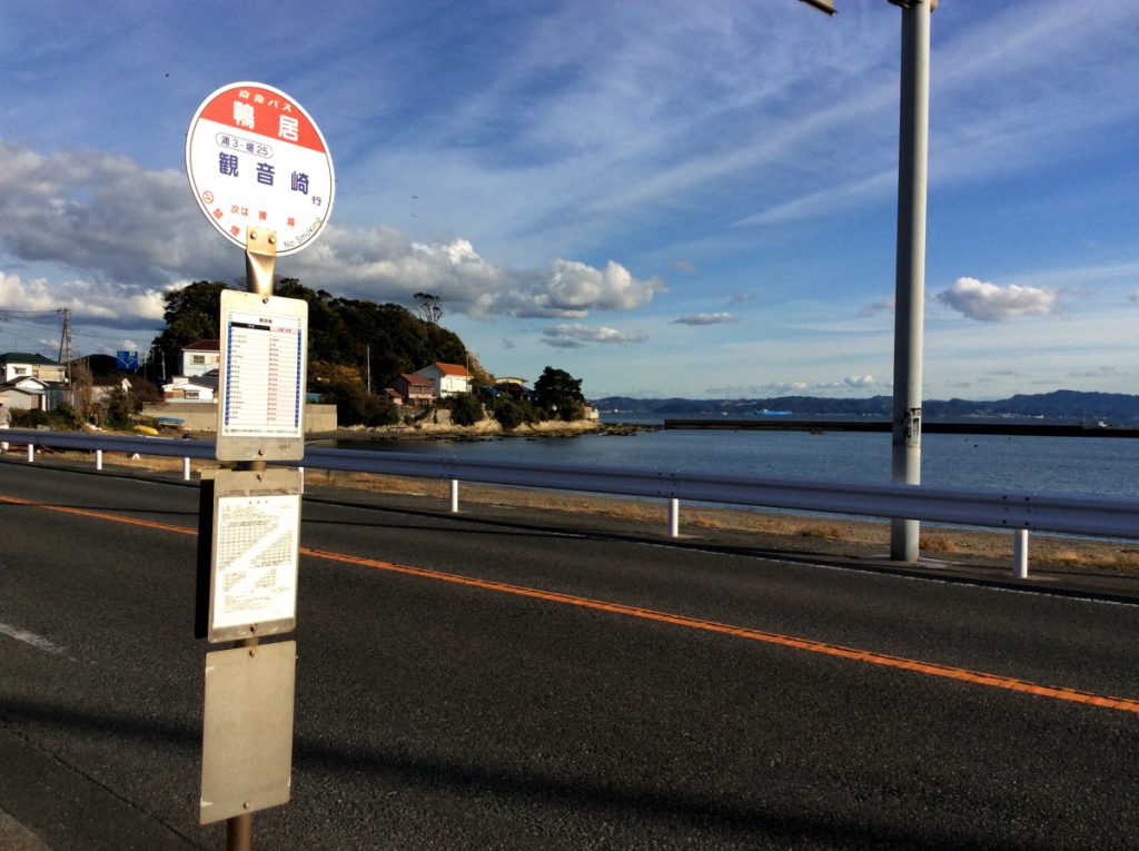 横須賀の「鴨鶴」前にあるバス停「鴨居」と道路を挟んだ先には青い海
