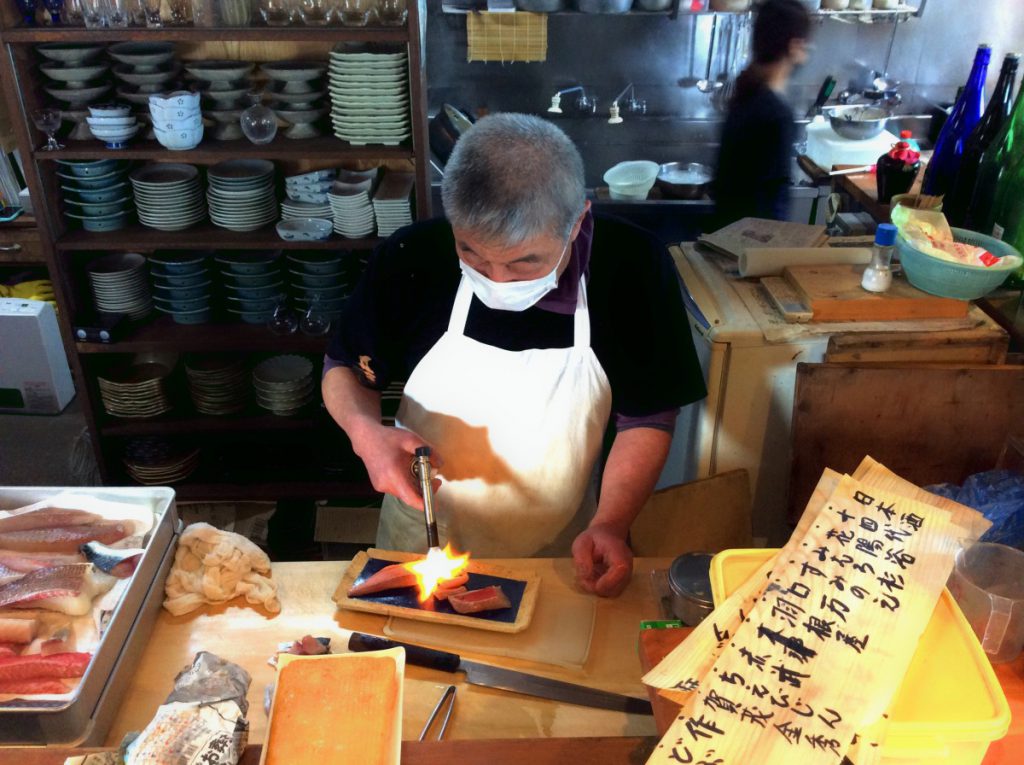 魚に焼き目を入れていく横須賀の「鴨鶴」の大将の様子