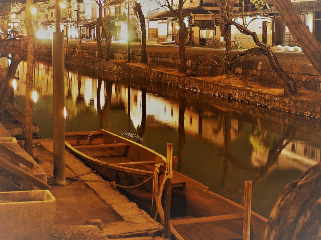 セピア色の写真。川に小舟が一艘止まっている。