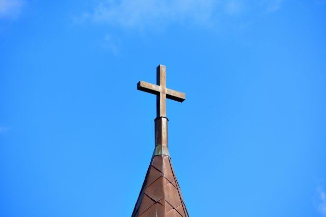 晴天を背景にした教会の天井上の十字。