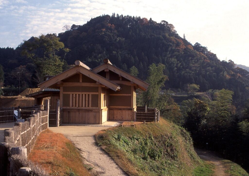 月山富田城跡に復元された当時の建造物跡や古道。奥には山々が見える。