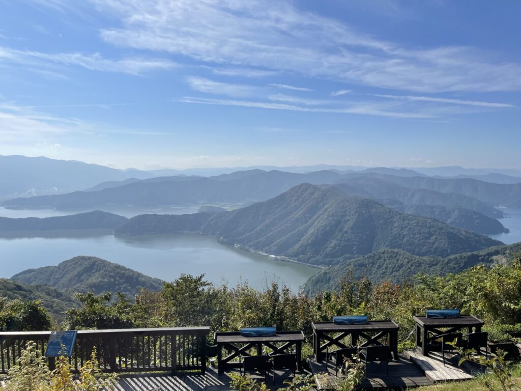 三方五湖を見下ろす二人掛け椅子。青い空と緑の丘に囲まれた三方五湖が見えます。