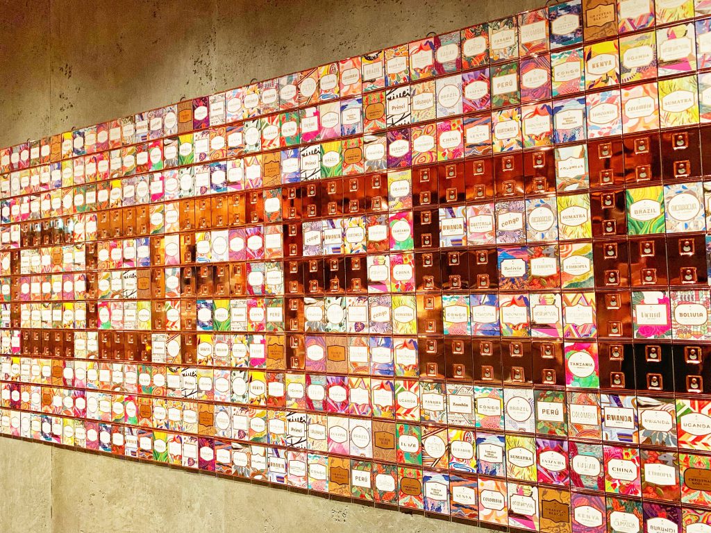 『STARBUCKS RESERVE® ROASTERY TOKYO』の写真。沢山のボックスが縦横に積まれており、遠目に見ると「COFFEE」の文字が浮かび上がるかのように見える。