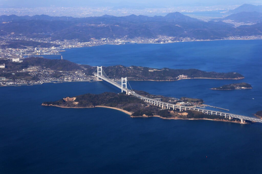 上空から眺めた瀬戸大橋。写真中央には櫃石島（ひついしじま）、奥には岡山県の児島半島が映っています。