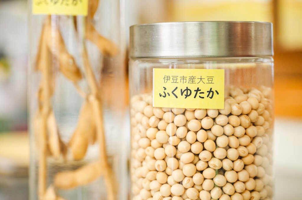 瓶に入れられている大豆。「伊豆市産大豆ふくゆたか」の黄色いラベルが貼られている