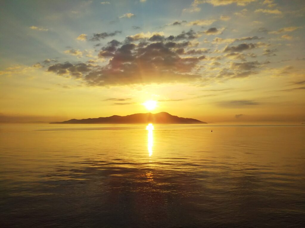 佐柳島の後方から朝日が昇り、あたり一面を黄金色に染めています。海面もリフレクションで輝いています。