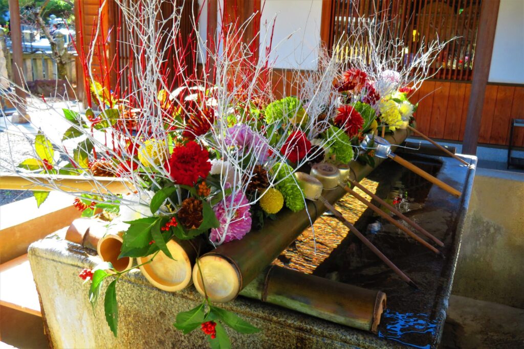 善通寺の花手水。竹の台の上にはカラフルな花々が飾られており、手杓が立てかけられています。