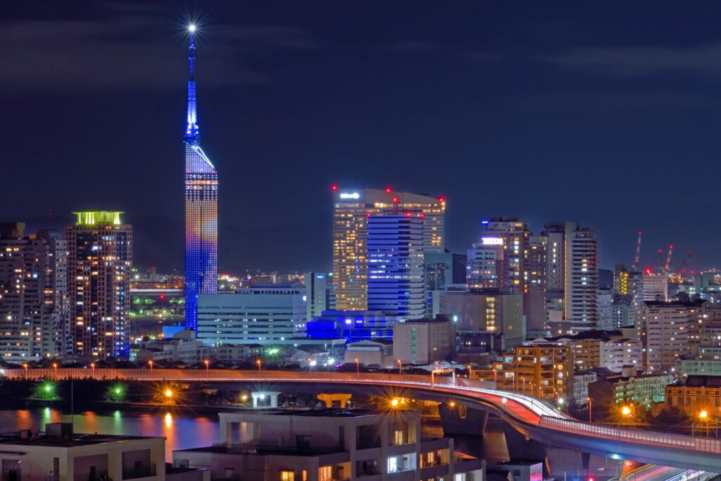 福岡の美しい夜景。福岡タワーと手前に海と都市道路が見える。