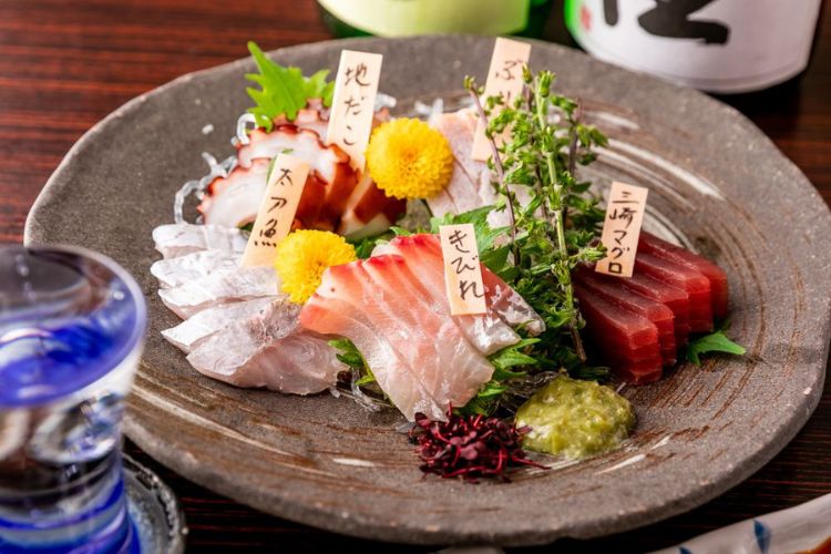 Fresh sashimi arranged on an earthenware plate.